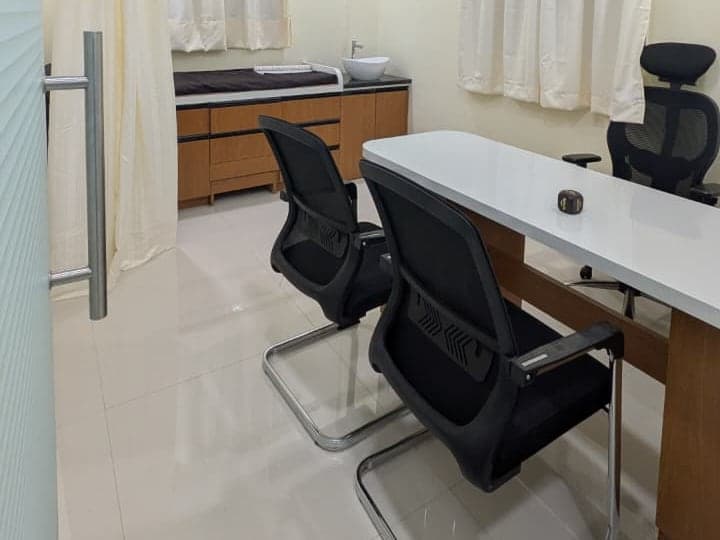 Second view of the consulting room, showing the patient chairs and curtained examination area