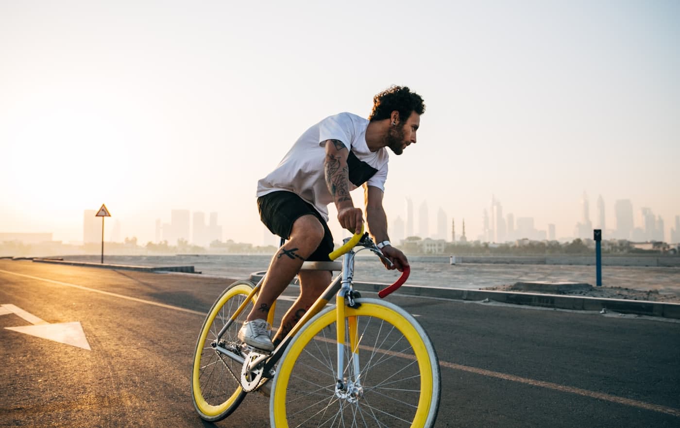 A cyclist riding on an open road at sunrise