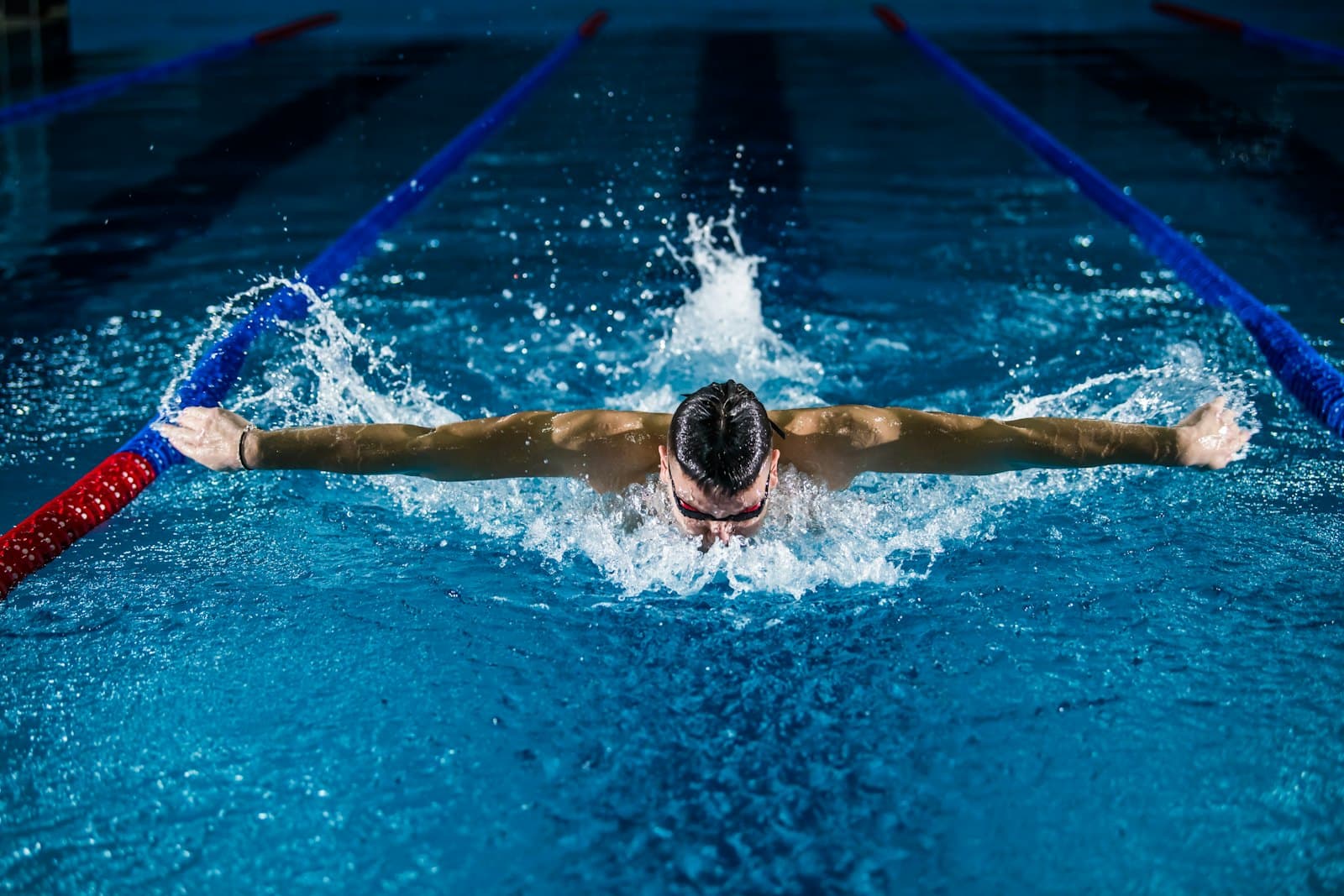 A swimmer mid-stroke in a pool lane