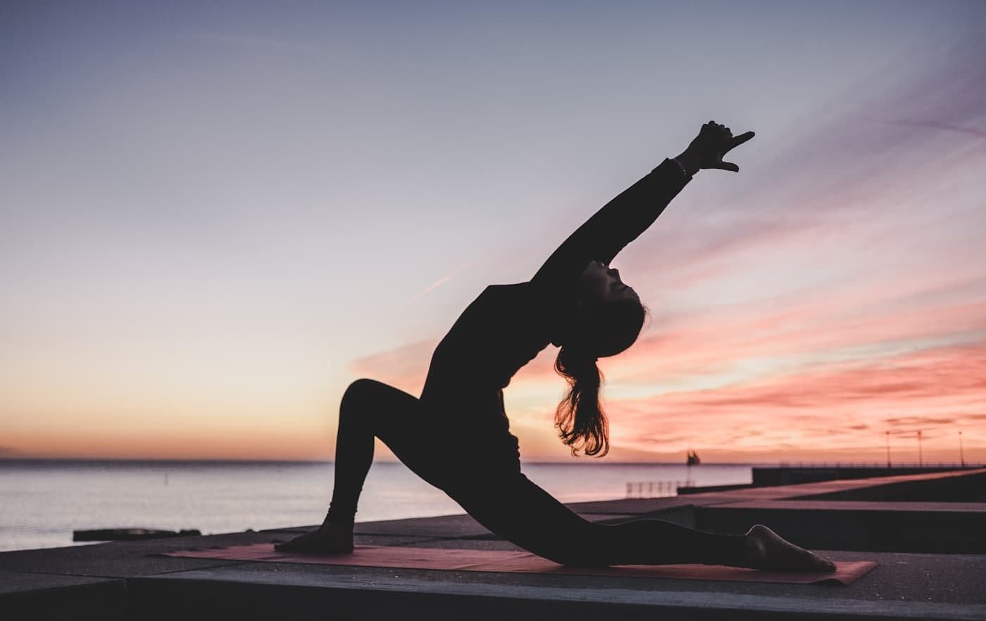 Silhouette of a person stretching at sunset